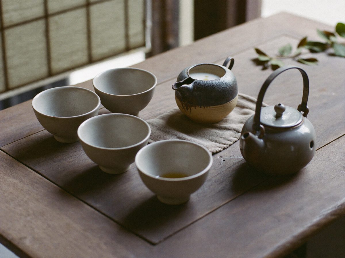 木のテーブルに並べた陶器の商品写真のイメージ