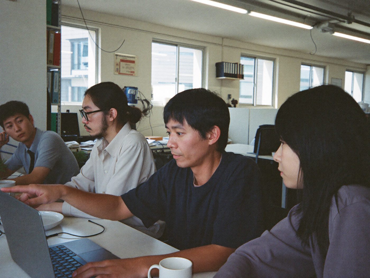 オフィスで打ち合わせをするスタッフの会社紹介写真のイメージ