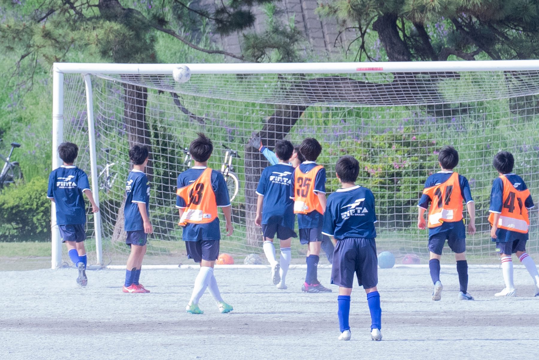 サッカーのゴール前でボールを追う子どもたち