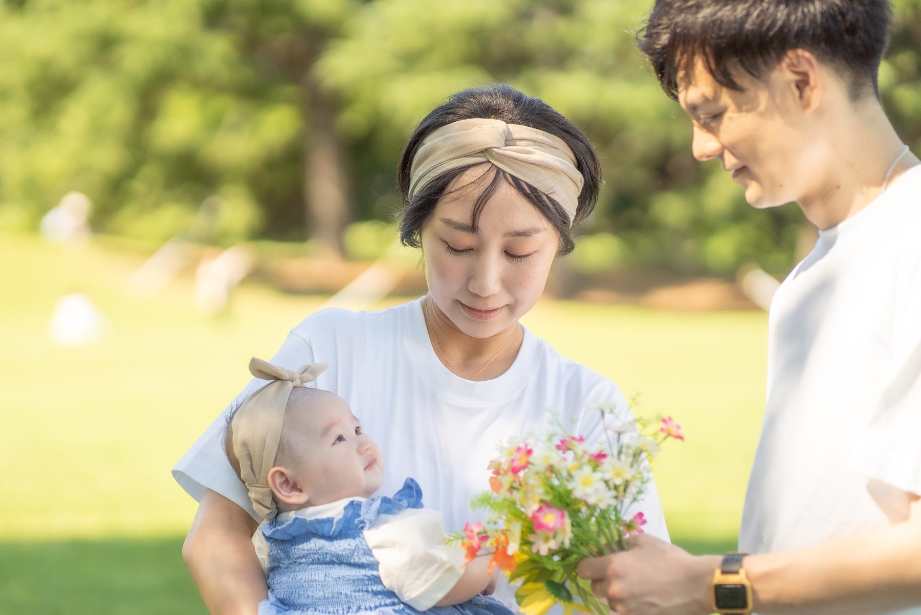 公園で花束を持つ家族と赤ちゃん