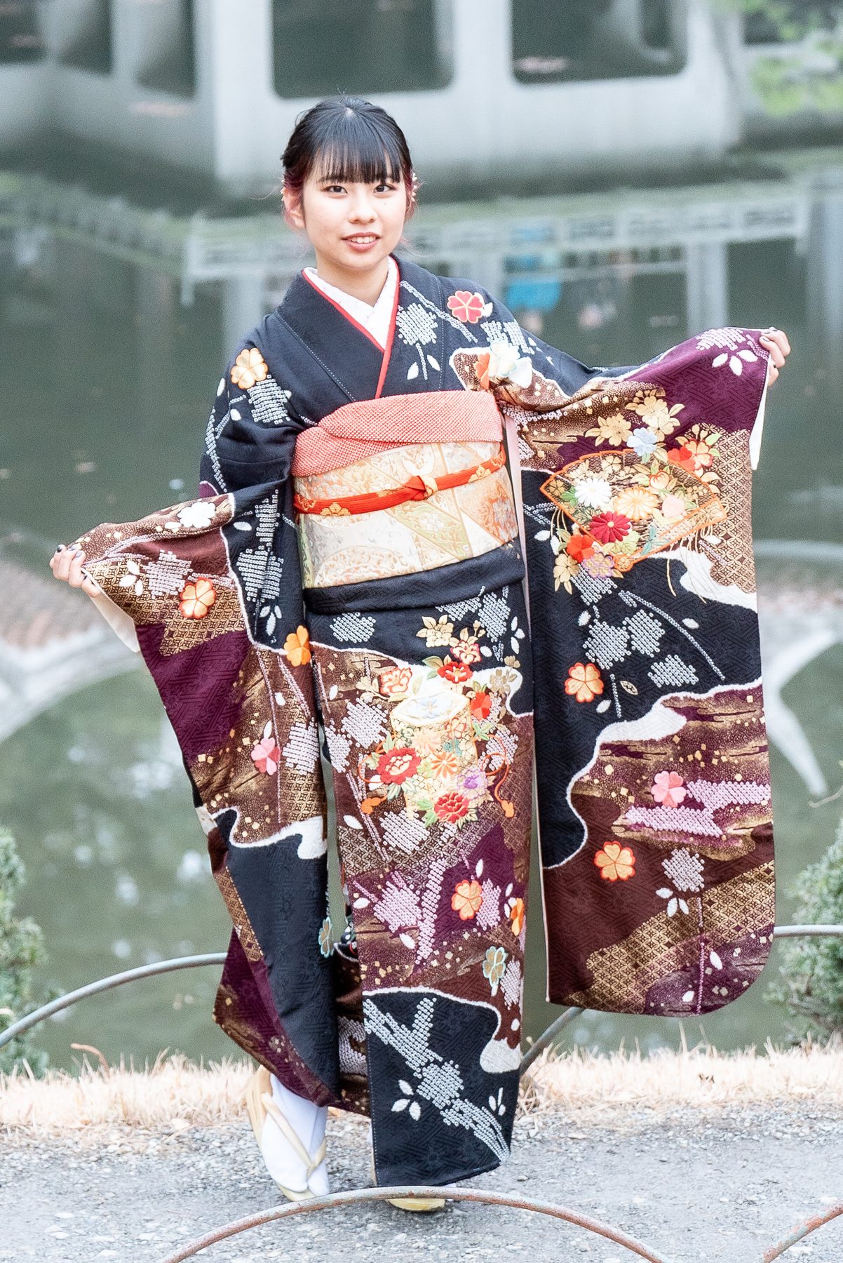 黒い振袖を広げて立つ成人式の全身写真
