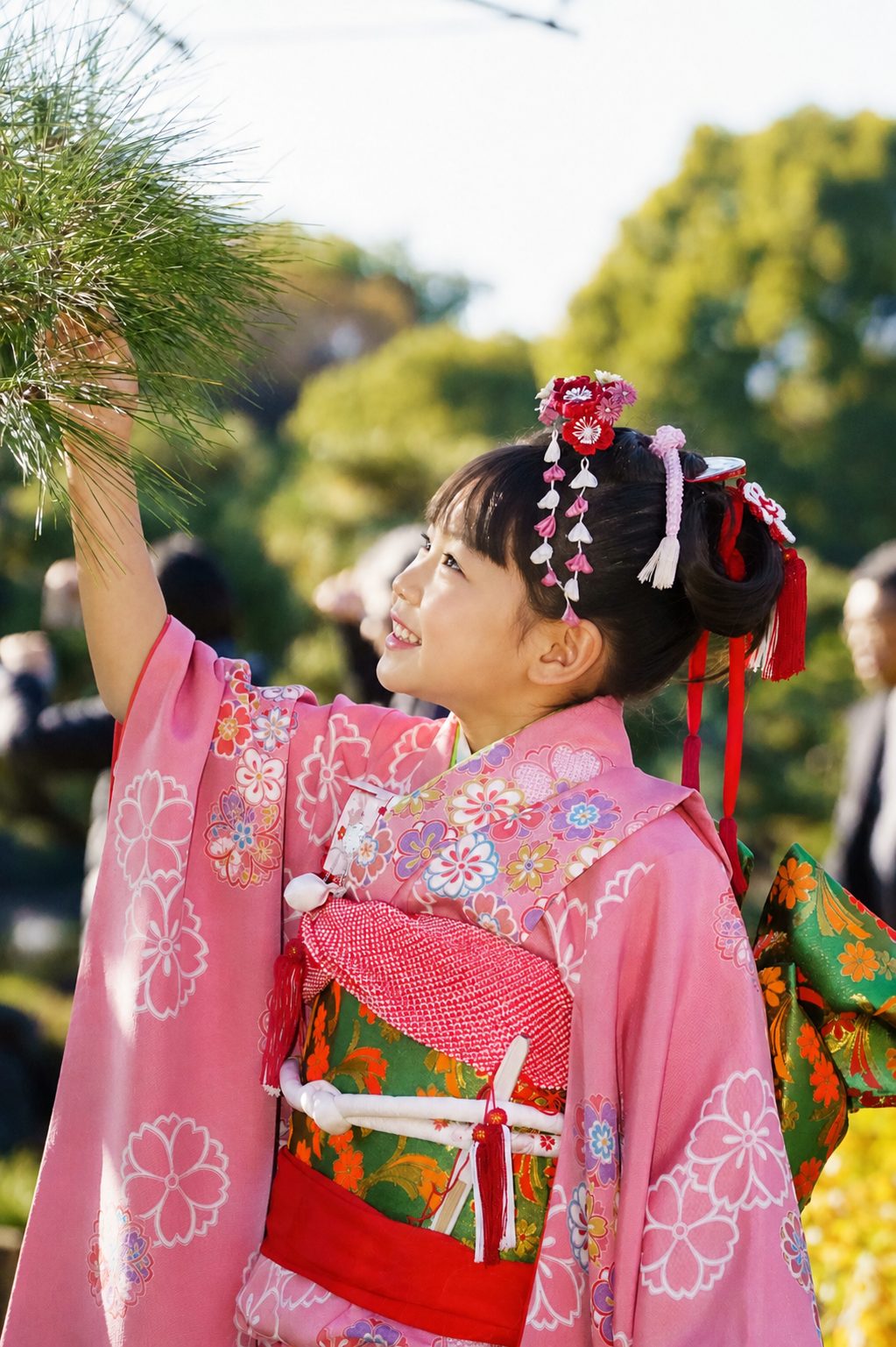 ピンクの着物で松に手を伸ばす七五三の女の子